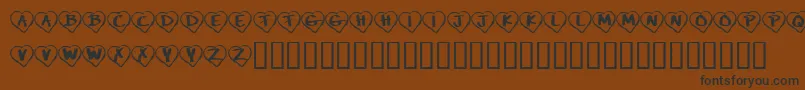フォントKrPaperHearts – 黒い文字が茶色の背景にあります