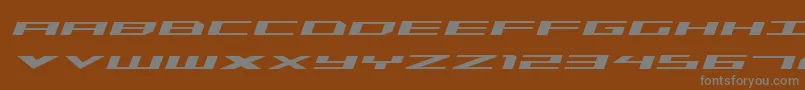 TriremeExpandedItalic-fontti – harmaat kirjasimet ruskealla taustalla