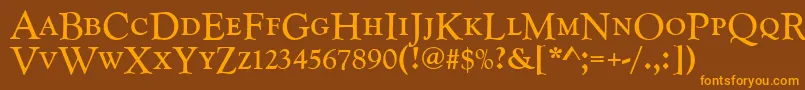 フォントGoudycatdcdreg – オレンジ色の文字が茶色の背景にあります。