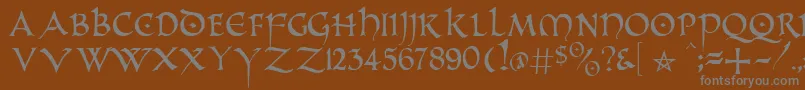 PrUncialAlternateCapitals-fontti – harmaat kirjasimet ruskealla taustalla