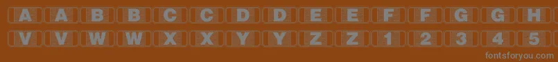 Stagtickets-fontti – harmaat kirjasimet ruskealla taustalla