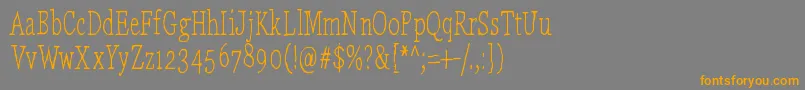 フォントLaikaComeHome – オレンジの文字は灰色の背景にあります。