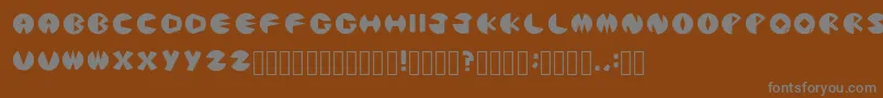 PacmanicRegular-fontti – harmaat kirjasimet ruskealla taustalla