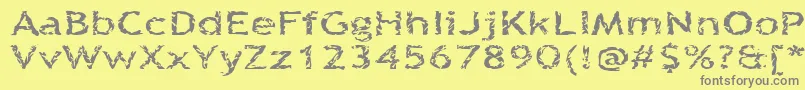 Quinquefoliolate-fontti – harmaat kirjasimet keltaisella taustalla