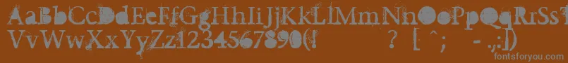 Undecapped-fontti – harmaat kirjasimet ruskealla taustalla