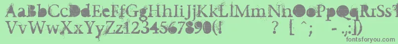Undecapped-fontti – harmaat kirjasimet vihreällä taustalla