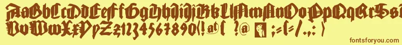 フォントGutjoeblack – 茶色の文字が黄色の背景にあります。