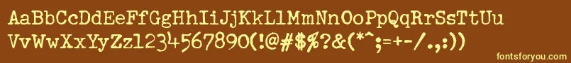 PfdumboldtypewriterOneNormal-fontti – keltaiset fontit ruskealla taustalla
