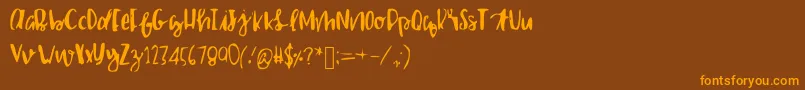 フォントShailettering – オレンジ色の文字が茶色の背景にあります。
