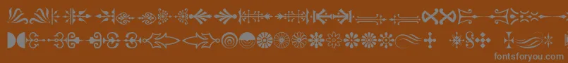 Pcornaments-fontti – harmaat kirjasimet ruskealla taustalla