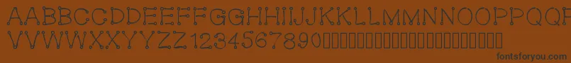 フォントOeillet – 黒い文字が茶色の背景にあります