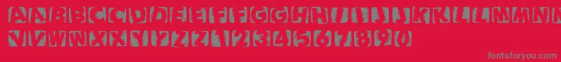 フォントWoodcuttedcapsinvers – 赤い背景に灰色の文字
