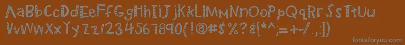 Kbradiowizard-fontti – harmaat kirjasimet ruskealla taustalla