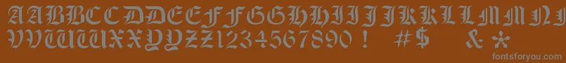 OldeStencil-fontti – harmaat kirjasimet ruskealla taustalla