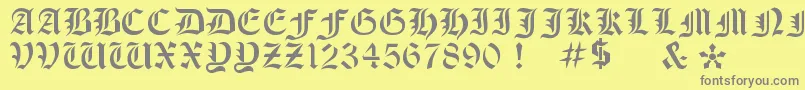 OldeStencil-fontti – harmaat kirjasimet keltaisella taustalla