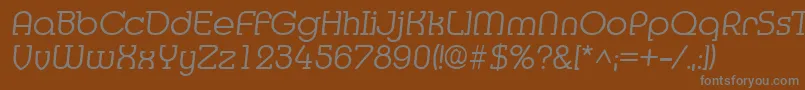 MediaItalic-fontti – harmaat kirjasimet ruskealla taustalla