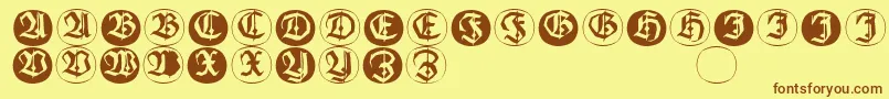 フォントFrakturinitialenangularround – 茶色の文字が黄色の背景にあります。