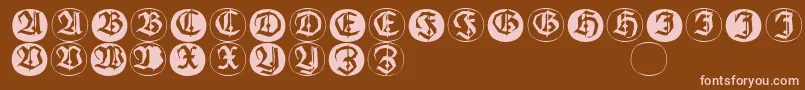 Frakturinitialenangularround-fontti – vaaleanpunaiset fontit ruskealla taustalla