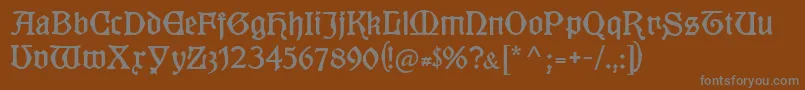 Kuenstlergotisch-fontti – harmaat kirjasimet ruskealla taustalla