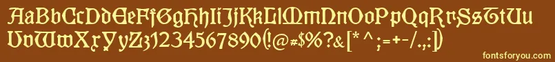 Kuenstlergotisch-fontti – keltaiset fontit ruskealla taustalla