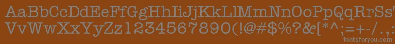 AmericantypewriterstdMed-fontti – harmaat kirjasimet ruskealla taustalla
