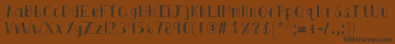 フォントKbswirlntwirl – 黒い文字が茶色の背景にあります