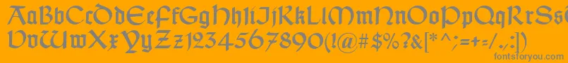 TypographerUncialgotisch-fontti – harmaat kirjasimet oranssilla taustalla