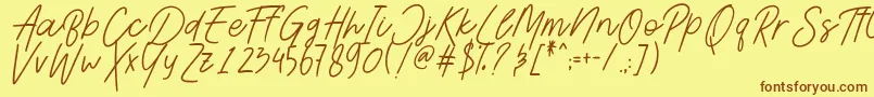 フォントAesthetikScriptDemo – 茶色の文字が黄色の背景にあります。
