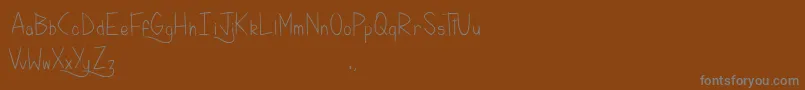KellyBrush-Schriftart – Graue Schriften auf braunem Hintergrund
