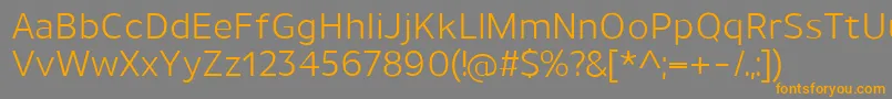 フォントUnimanRegular – オレンジの文字は灰色の背景にあります。