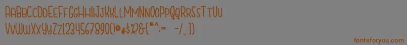 フォントCutiescapsFree – 茶色の文字が灰色の背景にあります。