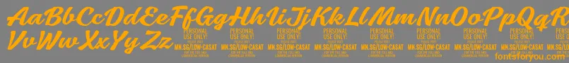 フォントLowcasatmedPersonalUse – オレンジの文字は灰色の背景にあります。