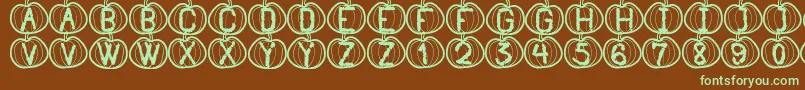 フォントPumpkinHalloweenSt – 緑色の文字が茶色の背景にあります。