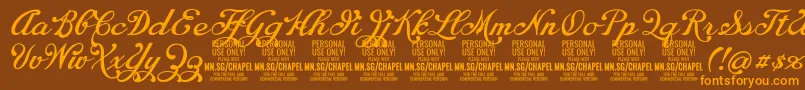 フォントChapelscriptPersonal – オレンジ色の文字が茶色の背景にあります。