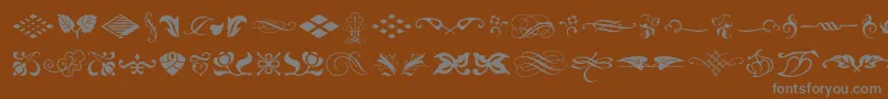 Czcionka Typeembellishmentsone – szare czcionki na brązowym tle