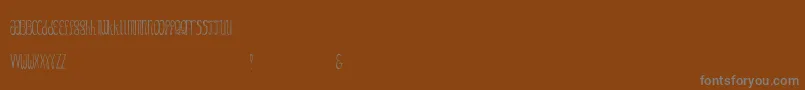 Fonte GezzyCondensedthin – fontes cinzas em um fundo marrom
