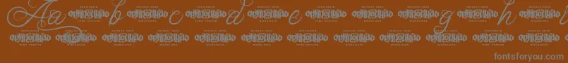 UnblessedScriptDemo-fontti – harmaat kirjasimet ruskealla taustalla