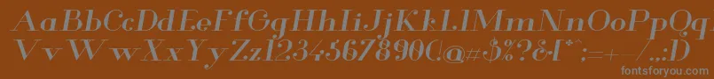 GlamorMediumextendeditalic-fontti – harmaat kirjasimet ruskealla taustalla