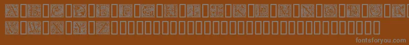 GoudyInitialen-fontti – harmaat kirjasimet ruskealla taustalla