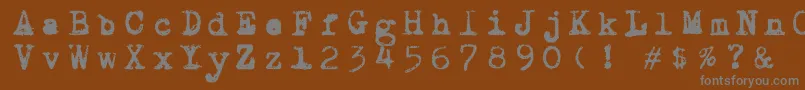 Draconiantypewritter001-fontti – harmaat kirjasimet ruskealla taustalla