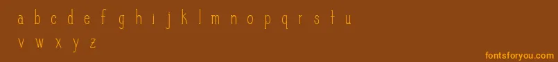 フォントSlimPickins – オレンジ色の文字が茶色の背景にあります。