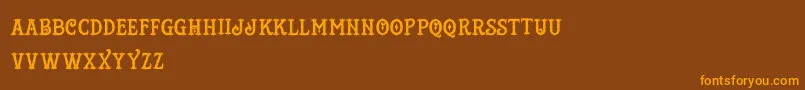 フォントTattooShop – オレンジ色の文字が茶色の背景にあります。