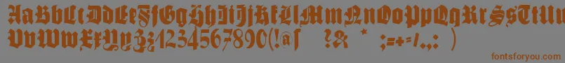 フォントSchmalegotischmk – 茶色の文字が灰色の背景にあります。