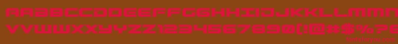 フォントGunshipacad – 赤い文字が茶色の背景にあります。