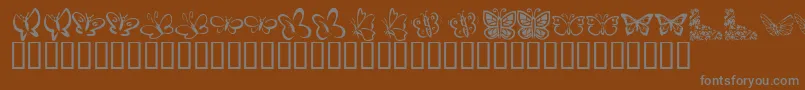 KrButterflies-Schriftart – Graue Schriften auf braunem Hintergrund