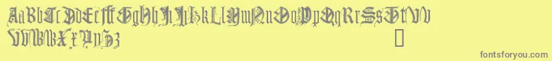 Monugd-fontti – harmaat kirjasimet keltaisella taustalla