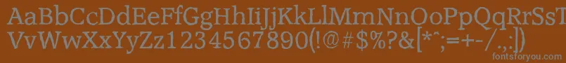 AccoladeantiqueRegular-fontti – harmaat kirjasimet ruskealla taustalla