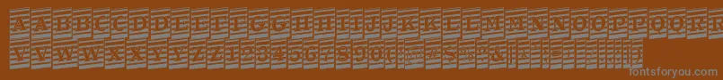 ATrianglercmmrup-fontti – harmaat kirjasimet ruskealla taustalla