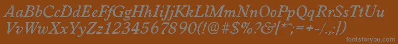 WorcesterserialMediumItalic-fontti – harmaat kirjasimet ruskealla taustalla