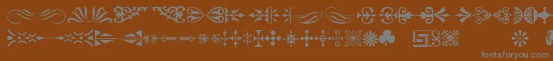 Ornamenttm-fontti – harmaat kirjasimet ruskealla taustalla
